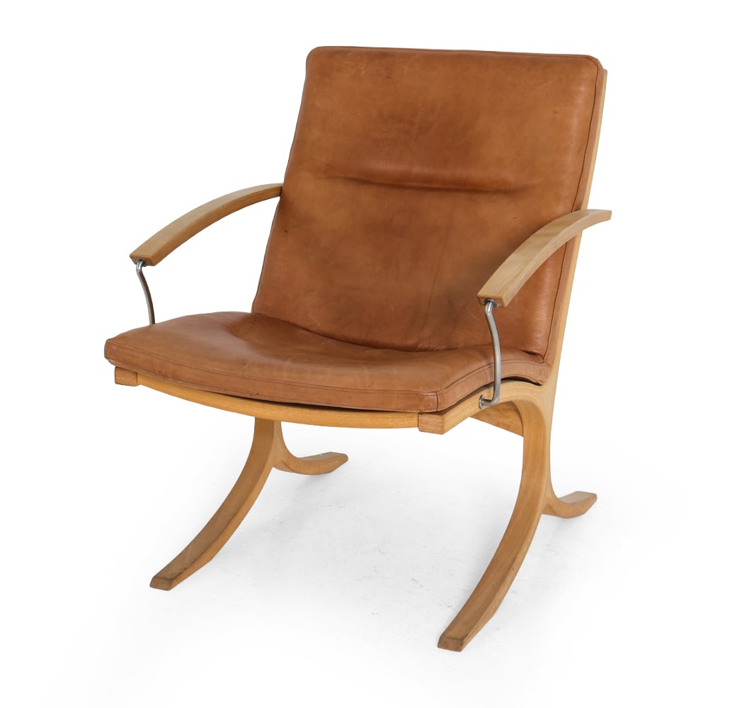 MOGENS HANSEN MODEL 213 LEATHER LOUNGE CHAIR 1960S: Beech frame and leather upholstery. Curved legs and metal bars connecting the armrests to the seat frame. Apparently unmarked. Denmark, circa 1960s. Dimensions: H 33" x W 22" x D 28" x SH 17" Conditio