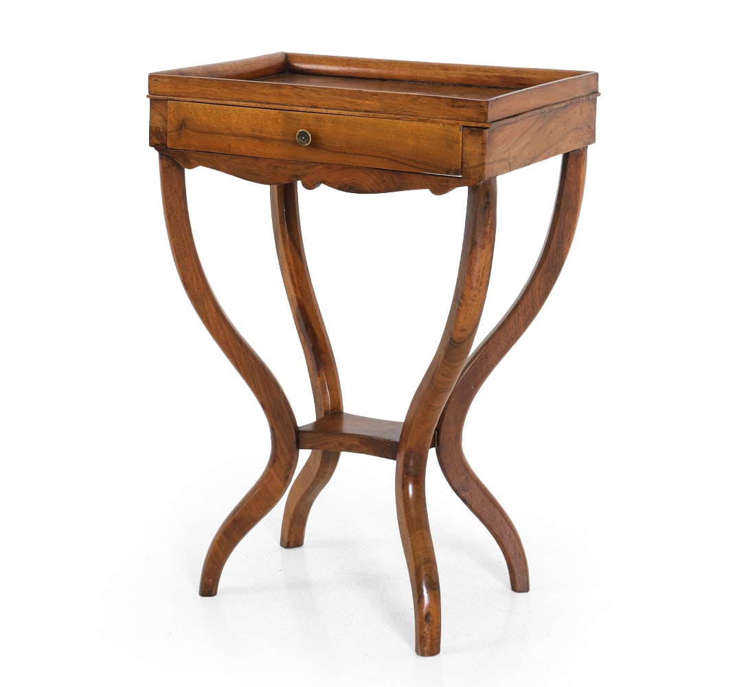 ANTIQUE DIRECTOIRE STYLE FRENCH WALNUT SIDE TABLE: Walnut side table with sculptural curved legs and one drawer. Tag inside reads 'Made in France'. Brass pull with floral design. Circa 19th century. Dimensions: H 27" x W 18.25" x D 12.25". Condition: 