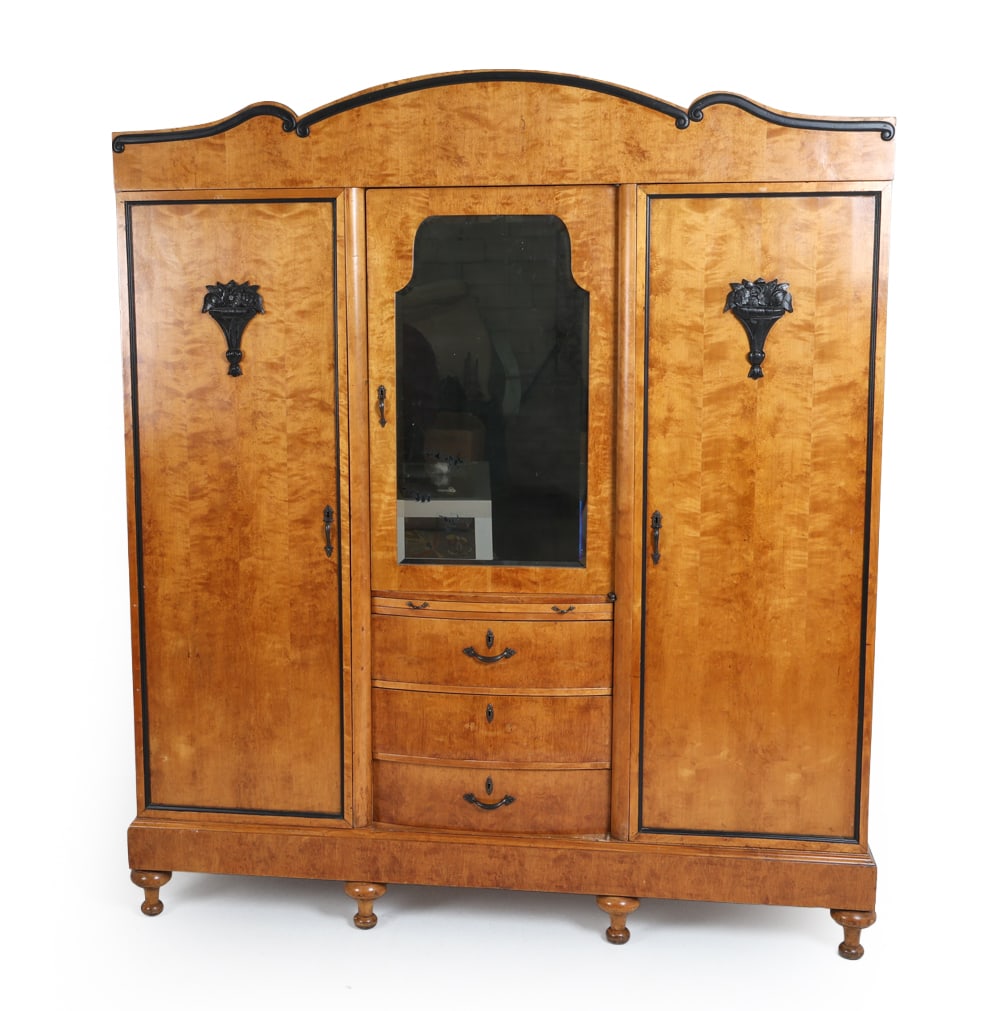 ANTIQUE ART DECO BIRCH ARMOIRE C. 1930S: Art Deco armoire wardrobe with birch veneer. Carved and painted decorative elements. Beveled glass mirror. Brass drawer pulls. Pull out tray surface. Circa 1930s. Dimensions: H 91" x W 77" x D 25.5". 