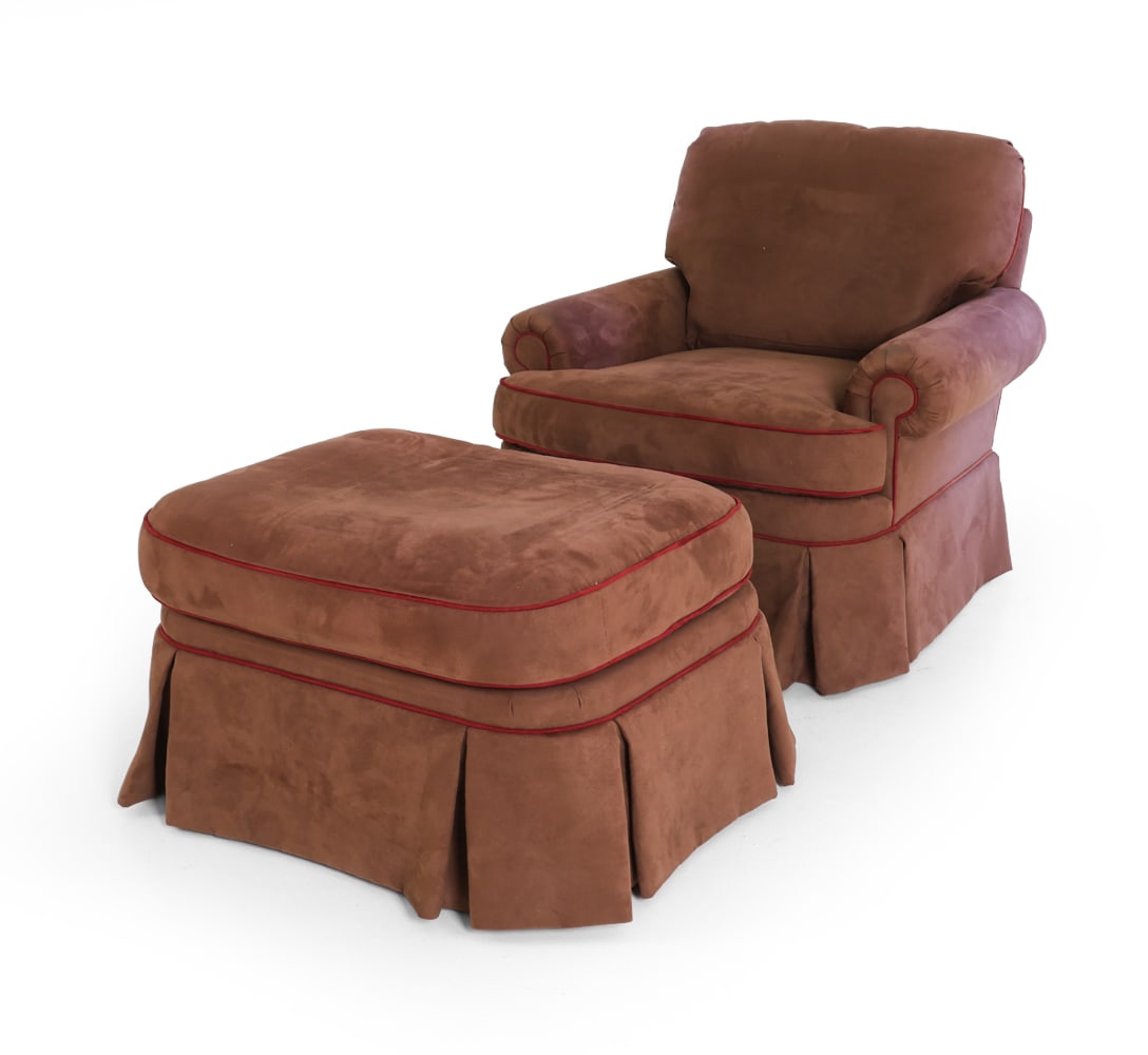 CHARLES STEWART SUEDE LOUNGE CHAIR & OTTOMAN: Marked underneath. Lounge chair in brown suede with red trim. Together with matching ottoman. 20th century. Dimensions: Chair H 30" x W 37.5" x D 31" x SH 18". Condition: Light scuffs and scratches to