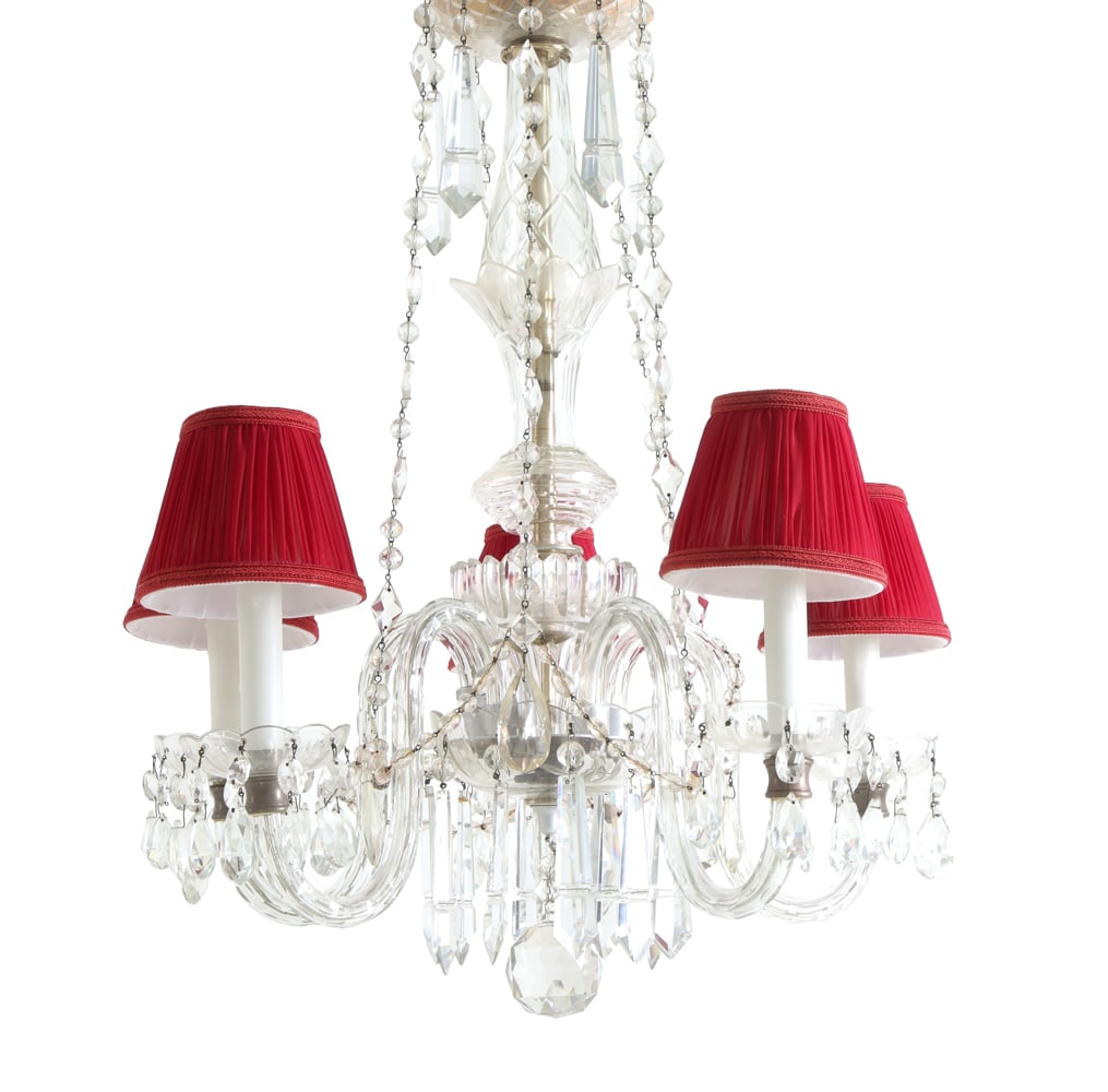 FRENCH BACCARAT STYLE BRASS & CRYSTAL CHANDELIER: Crystal chandelier with curved arms and several faceted pendants and drops. Pleated red shades. Brass ceiling plate. Candle-form light sockets. 20th century. Dimensions: H 25" x Dia. 21". Condition:
