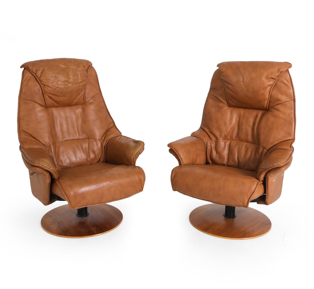 PAIR OF HJORT KNUDSEN LEATHER SWIVEL CHAIRS 1970S: For Broderna Andersson. Brown leather upholstery on teak swivel bases. Tagged to side and under base. Denmark, circa 1970s. Dimensions: H 44.5" x W 32" x D 26.5" x SH 16.5". Condition: Rubs and fading
