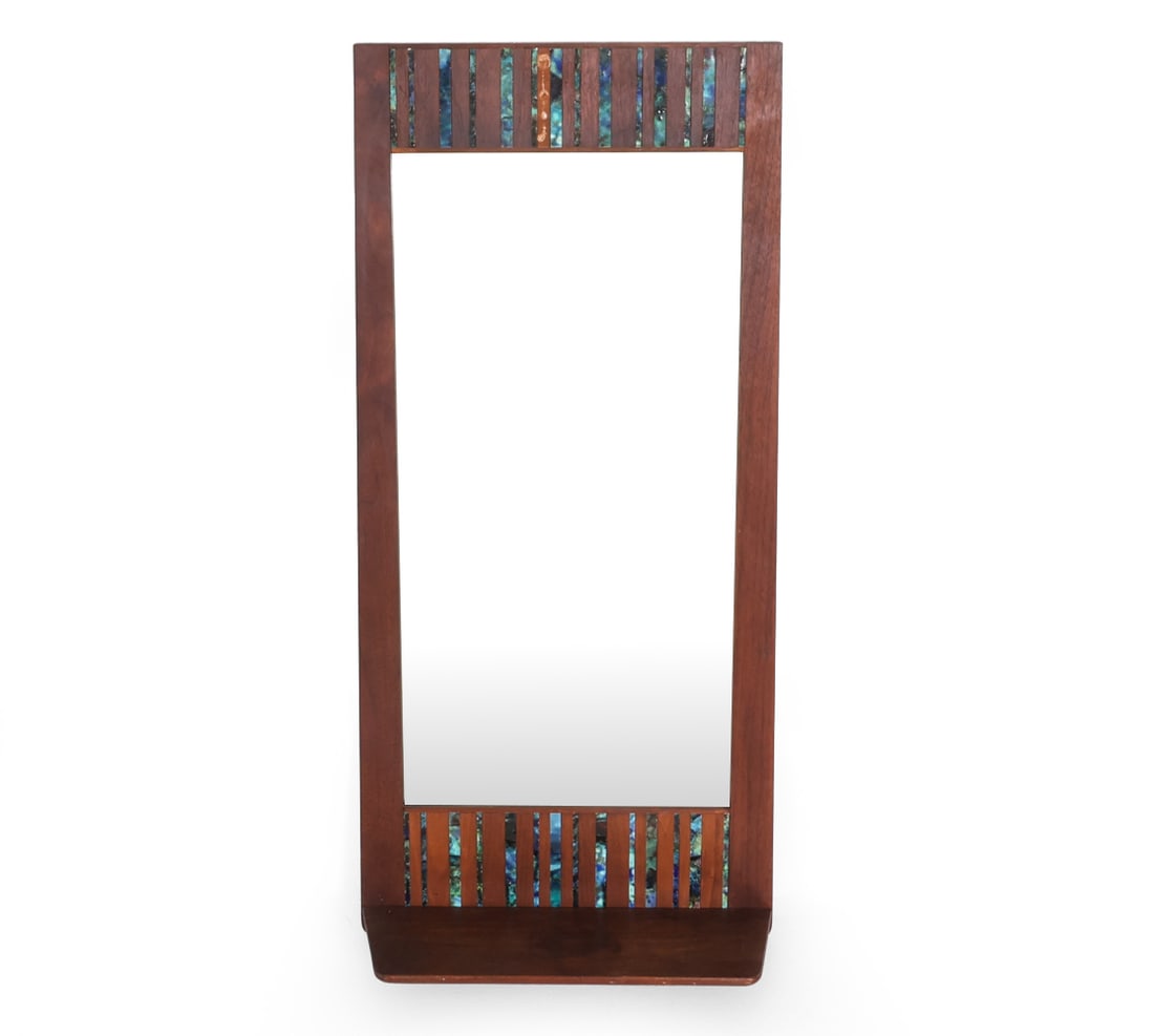HARRIS STRONG WALNUT & CERAMIC MIRROR W/ SHELF: Walnut wall mirror with multicolored ceramic accents inlaid to top and bottom. Lower shelf to bottom of mirror. Apparently unmarked. Circa 1960s. Dimensions: H 40" x W 18.5" x D 7.75". Condition: Mino