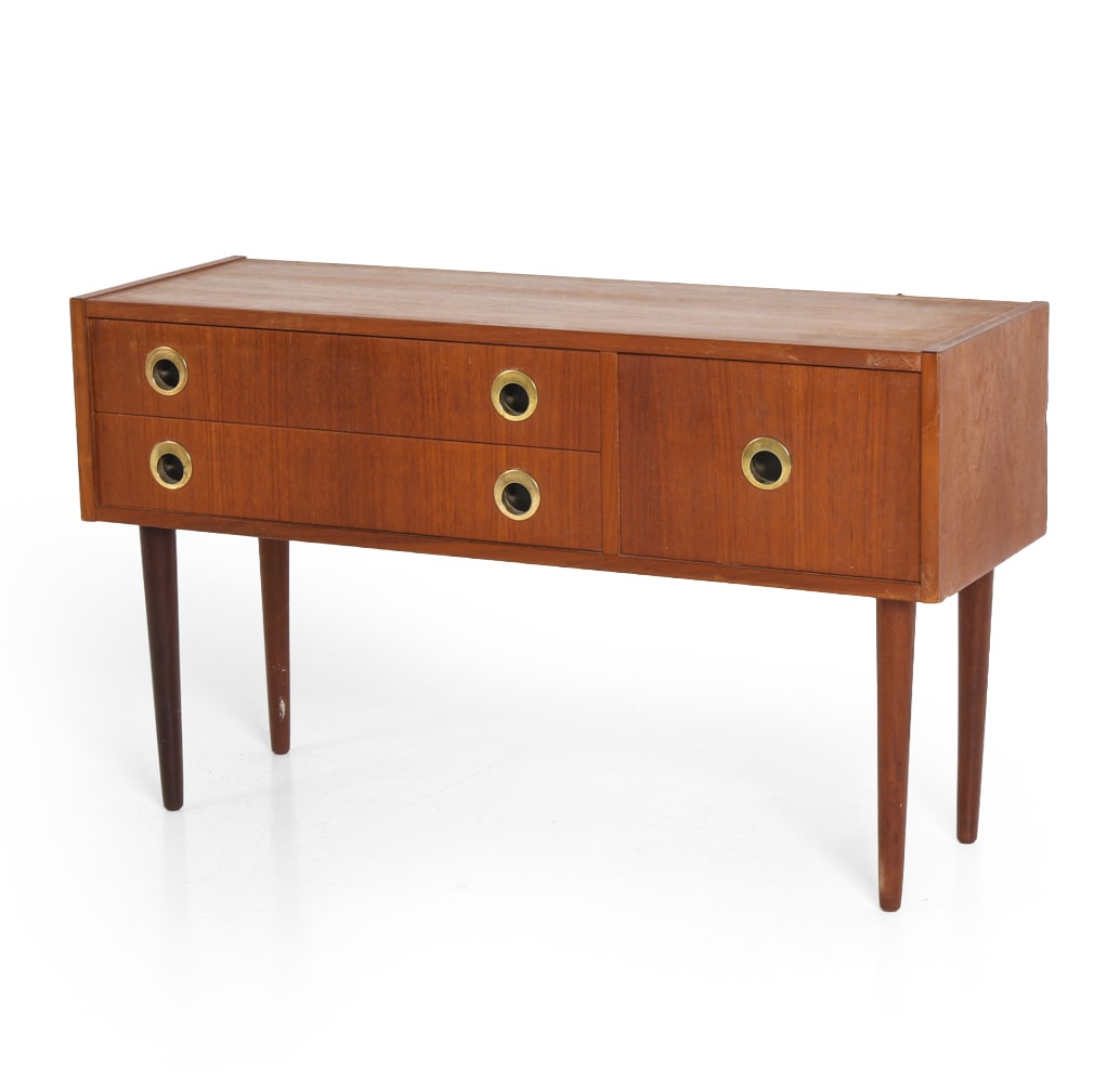 SCANDINAVIAN TEAK LOW CHEST C. 1960S: Chest of drawers in teak veneer with three drawers and circular brass drawer pulls. Scandinavian, circa 1960s. Dimensions: H 20.25" x W 35" x D 12". Condition: Few scuffs, small dings to edges. Wear c