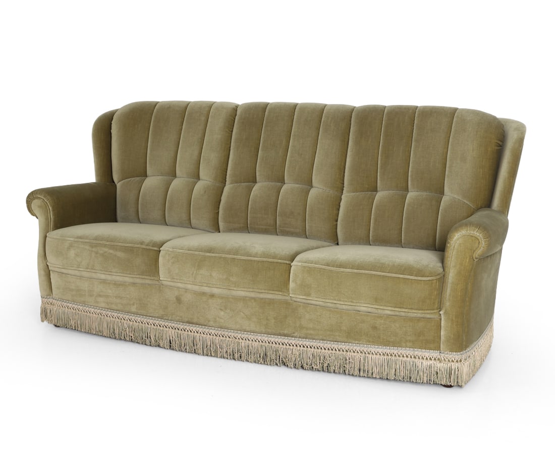 DANISH MID-CENTURY VELOUR SOFA C. 1970S: Three-seater sofa in light green velour upholstery with fringe trim. Channel tufting backrest and rounded arms. Denmark, circa 1970s. Dimensions: H 35" x W 75" x D 33" x SH 16" Condition: Wear consist