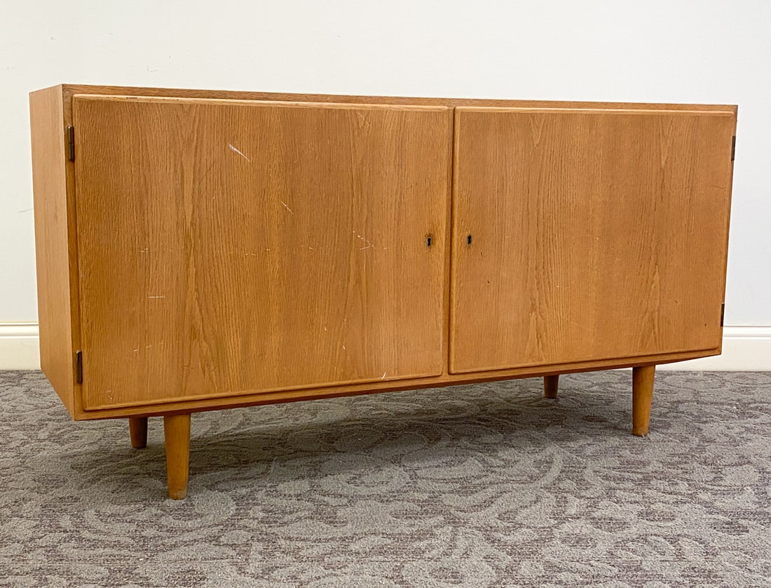 POUL HUNDEVAD DANISH OAK CABINET C. 1970S: Key Included. Marked to back. Denmark, circa 1970s. Dimension: H 28.25" x W 54.5" x D 17.25" Condition: Scuffs and rubs to top and sides, Loss of finish to top, Wear consistent with age and use.