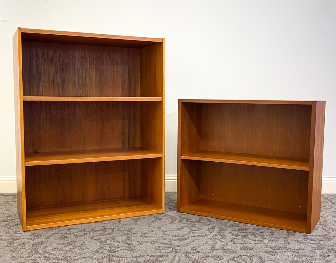 MOGENSEN STYLE DANISH TEAK BOOKCASES C. 1960S: (2) Total. Dimensions: (Largest) H 43" x W 33" x D 15" Condition: Wear consistent with age and use. Fading, discoloration spots, nicks, scuffs. Smaller unit has minor soiling spots to top.