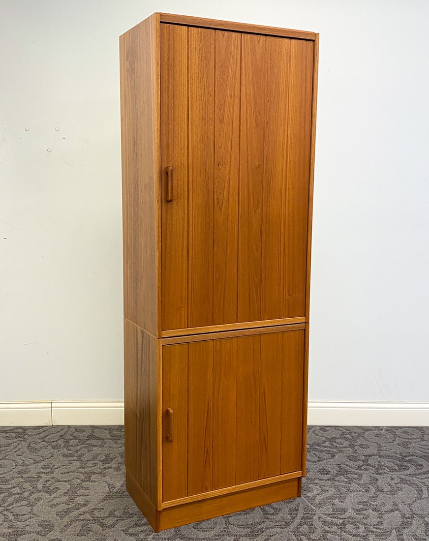 DANISH TEAK CABINET C. 1960S: Two-piece unit. In teak. Denmark, circa 1960s. Dimension: H 71.75" x W 25" x D 16" Condition: Light surface wear consistent with age and use.