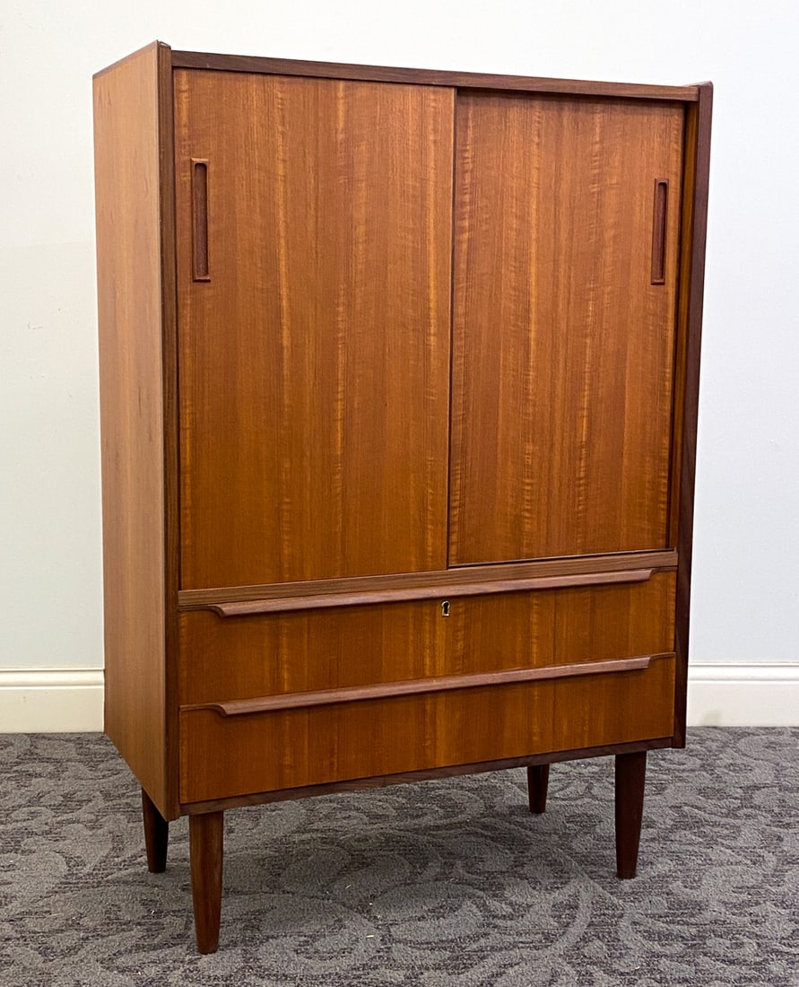 VODDER STYLE DANISH TEAK CABINET C. 1970S: Denmark, circa 1970s. Dimensions: H 46.5" x W 31.5" x D 15.5" Condition: Wear consistent with age and use including minor rubs and scuffs, water mark to top.
