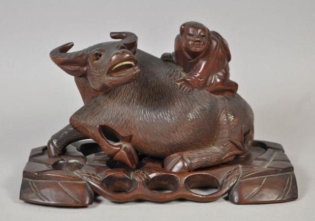CHINESE CARVED WOODEN MAN RIDING AN OX: Chinese carved man riding an ox with ivory teeth. In very good condition. Dimensions: H 5.5" X L 9" X W 4.5" From a Riverdale/Bronx, NY Estate
