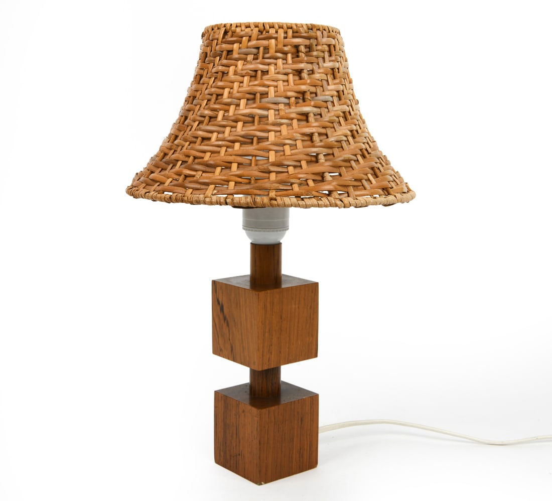 SWEDISH ROSEWOOD TABLE LAMP C. 1960S: Dimensions: H 13" x Dia. 8.5". Condition: Wiring untested, European plug. Few breaks and scuffs to rattan shade. Wear consistent with age and use. PT157