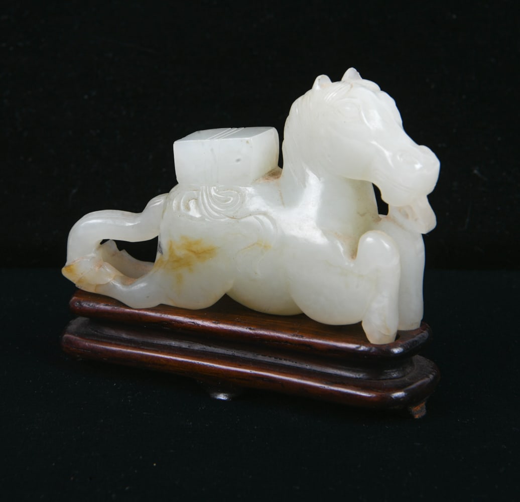 CHINESE CARVED JADE HORSE FIGURE: On wooden stand. Dimensions: H 1.75" x W 3". Condition: Faint scuffs. Wear consistent with age.