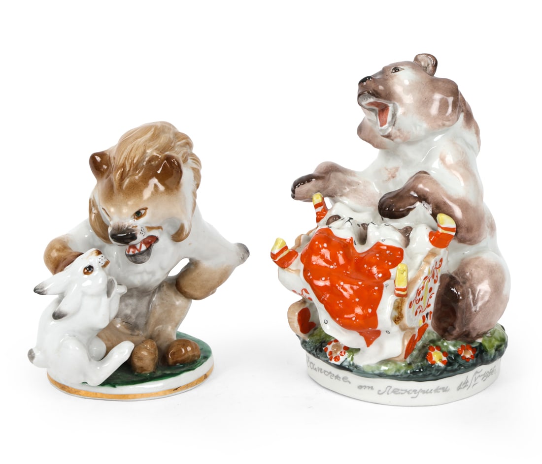 LOMONOSOV SOVIET RUSSIAN PORCELAIN FIGURINES 1950S: (2) Figurines titled "Lion and Hare" & "Bear mother with a cradle". Marked underneath. USSR, circa 1950s. Dimension: (Largest) H 6.75" x W 4.25" x D 5" Condition: Light surface wear consistent with