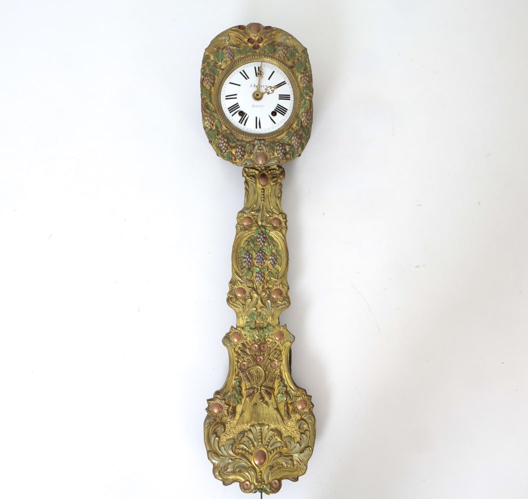 FRENCH BRASS MORBIER WAG ON THE WALL CLOCK: Repousse (embossed) brass bezel and a matching pendulum shroud. Porcelain enamel dial with Roman numerals. Marked "J. Bloyet. Carentoir" in the dial. France, 19th century. Dimensions: H 52? x W 12?