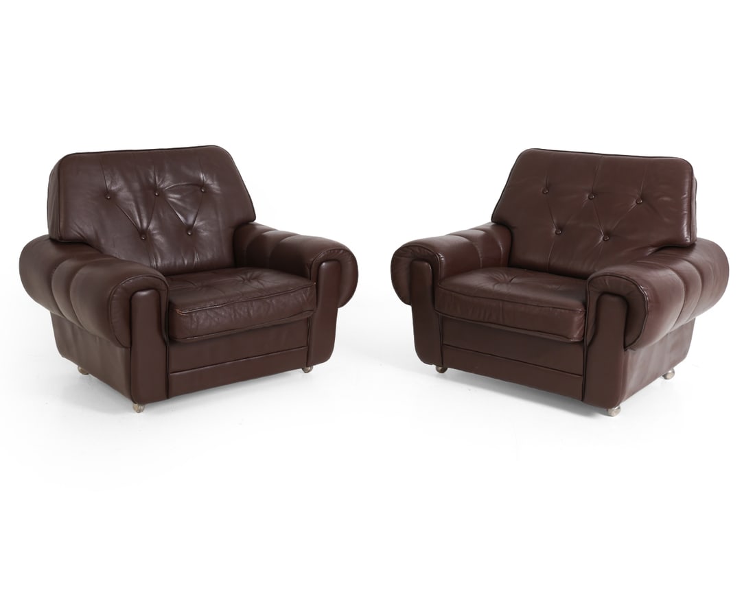PAIR OF SCANDINAVIAN LEATHER LOUNGE CHAIRS 1970S: On chrome castors. Dimensions: H 31.5" x W 37.25" x D 34" x SH 15". Condition: Rubs and small flaking spots to leather. Wear consistent with age and use. F033
