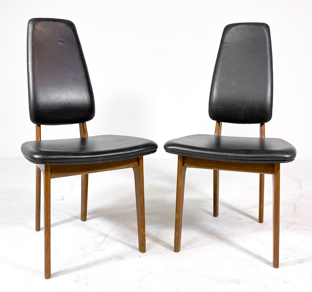 PAIR ERIK BUCH FOR DOMUS DANICA TEAK DINING CHAIRS: Tagged underneath. Teak frames with black leather upholstery. Denmark, circa 1960s. Dimensions: H 37.5" x W 17" x D 20.5" x SH 18". Condition: Scuffs and tears to wood and leather, wear consistent