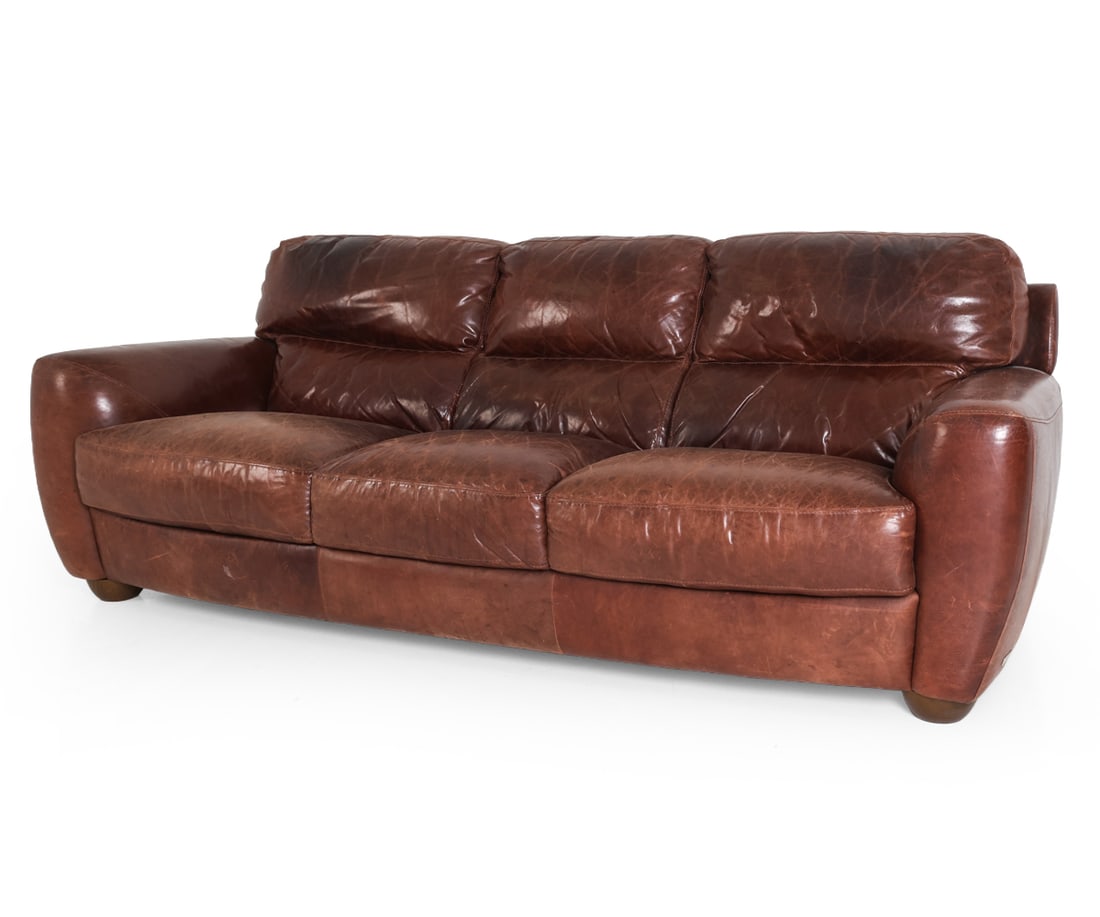SOFITALIA INTERNATIONAL ITALIAN LEATHER SOFA: Three-seater sofa upholstered in brown leather. Segmented backrest cushions, rounded arms and walnut feet. Tagged to leather. Italy, 21st century. Dimensions: H 34" x W 87" x D 36" x SH 18"