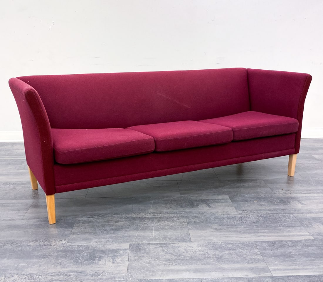 NIELAUS DANISH 'LONDON' SOFA C. 1970S: Three-seat sofa in burgundy wool upholstery. Beech legs. Apparently unmarked. Denmark, circa 1970s. Dimensions: H 29" x W 74.5" x D 26" x SH 17.5". Condition: Few faint discolored areas to fabric.