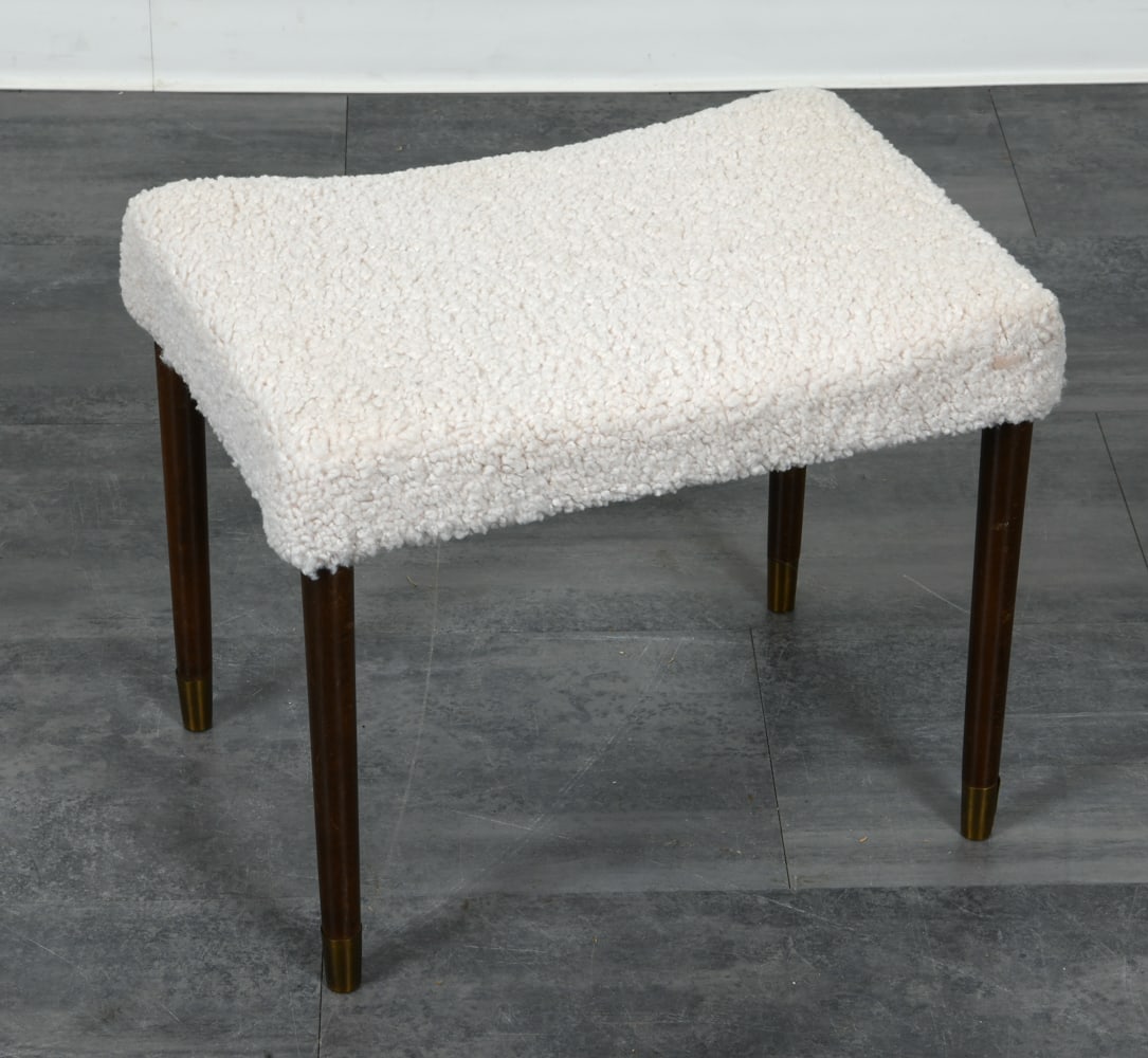 DANISH LAMBS WOOL OTTOMAN FOOTSTOOL C. 1960S: Ottoman with lambs wool upholstered seat. Tapered beech legs with brass caps. Denmark, circa 1960s. Dimensions: H 17" x W 19" x D 13.5". Condition: Split to brass cap on one foot. Wear consistent
