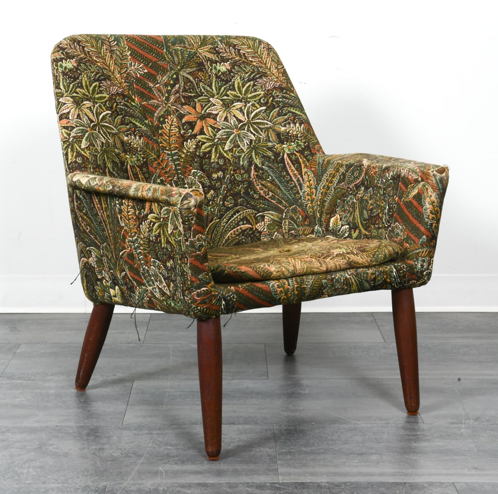 SCANDINAVIAN BOTANICAL PATTERNED LOUNGE CHAIR: Lounge chair with green botanical design to fabric upholstery. Tapered teak pegs. Scandinavian, circa 1960s. Dimensions: H 30" x W 28" x D 25" x SH 15". Condition: Reupholstery recommended Scuffs to