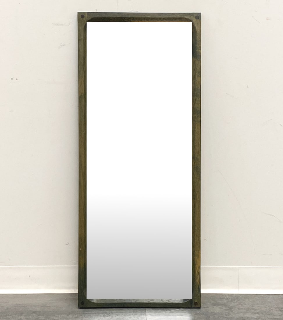AKSEL KJERSGAARD ODDER DANISH OAK WALL MIRROR: Stained oak frame. Marked to back. Denmark, circa 1960s. Dimensions: H 42" x W 17" Condition: Wear consistent with age and use. Heart shaped sticker residue to glass.