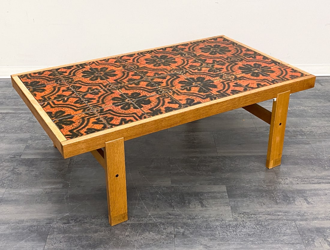 MID-CENTURY DANISH TILE TOP COFFEE TABLE: Mosaic tile top coffee table with oak frame. Denmark, circa 1960s. Dimensions: H 21" x W 58.5" x D 34.5" Condition: Wear consistent with age and use. Sign or repair to one leg. Scuffs, minor nicks to 