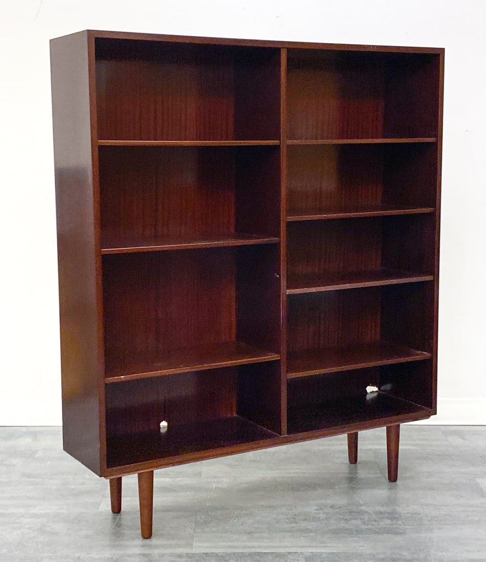 OMANN JUN DANISH MAHOGANY BOOKCASE C. 1960S: Seven adjustable shelves In mahogany. Marked to back. Denmark, circa 1960s. Dimensions: H 55.5" x W 47.25" x D 11.5" Condition: Wear consistent with age and use. Nicks, scuffs. Minor dings to two shel