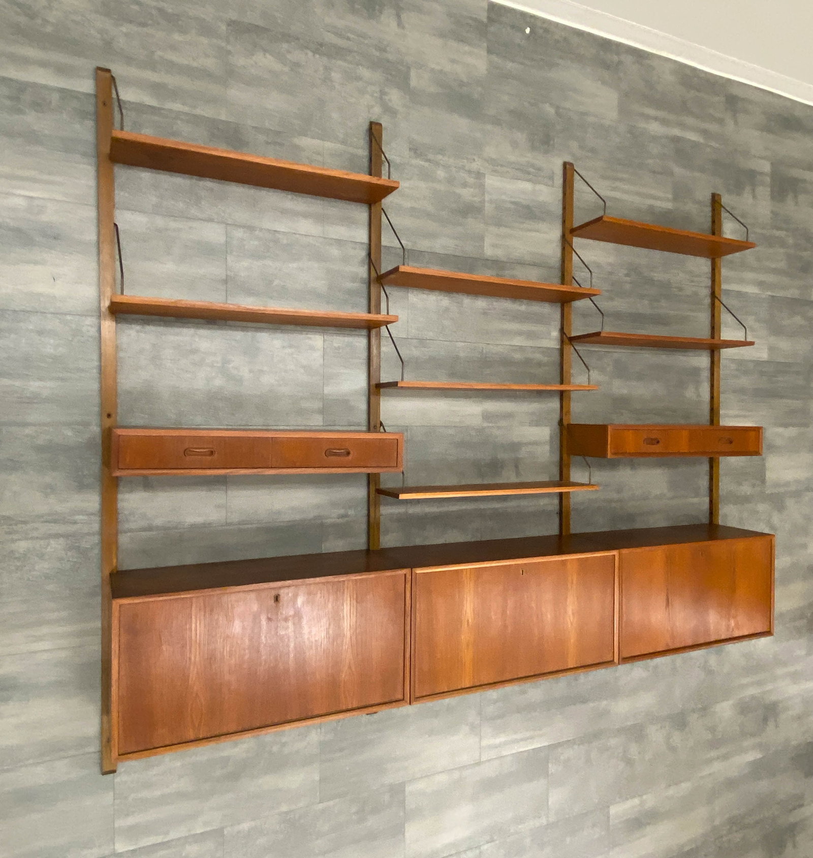 POUL CADOVIUS ROYAL SYSTEM TEAK WALL UNIT C. 1960S: For Cado. Key included. Modular wall unit with shelves & cabinets. Adjustable heights for all pieces. Hardware included. Denmark, circa 1960s.. Dimensions: H 77.5'' x W 96.5'' x D 12'' Condition: Wear
