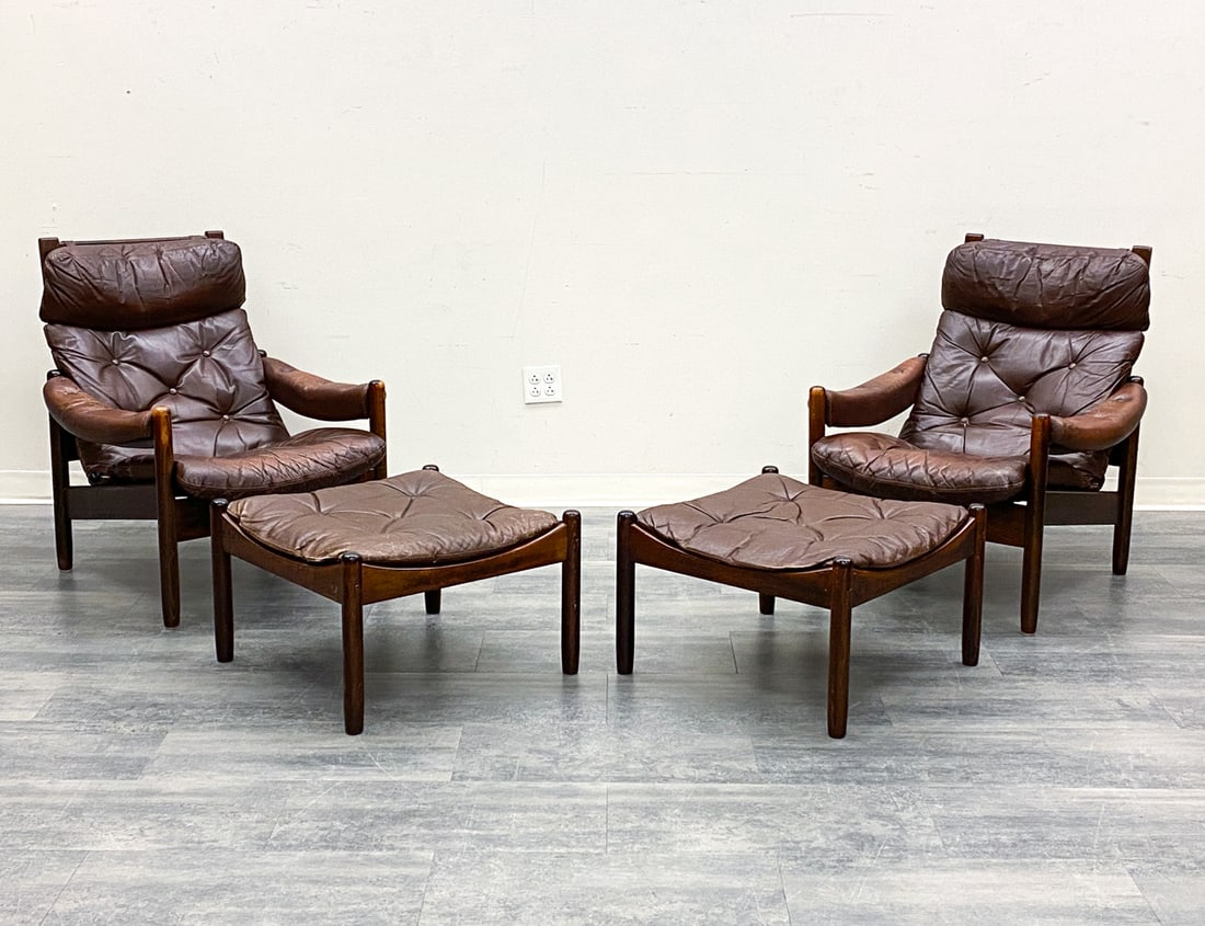 PAIR J. M. BIRKING & CO LEATHER CHAIRS W/ OTTOMANS: Stained beech frame and leather upholstery. Marked to underside. Denmark, circa 1960s. Dimensions: H 35" x W 30" x D 31" x SH 16" (Ottoman) H 15.25" x W 24.25" Condition: Wear consistent with age and 