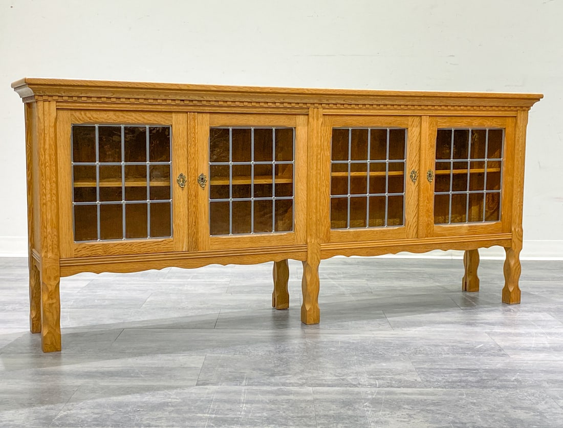 KJAERNULF STYLE DANISH OAK & GLASS DOOR SIDEBOARD: Key included. Four glass doors and brass hardware. In oak. Denmark, circa 1970s. Dimensions: H 28.25'' x W 75.5'' x D 13.5 Condition: Wear consistent with age and use. Minor scuffs to top.