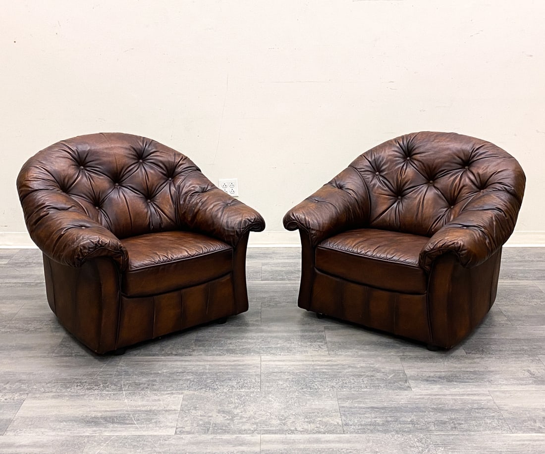 PAIR OF CHESTERFIELD STYLE LEATHER LOUNGE CHAIRS: Tufted design. Leather upholstery. On casters. European. Dimensions: H 35" x W 35" x D 37" x SH 16.5" Condition: Wear consistent with age and use. Some scuffs and wear to leather.