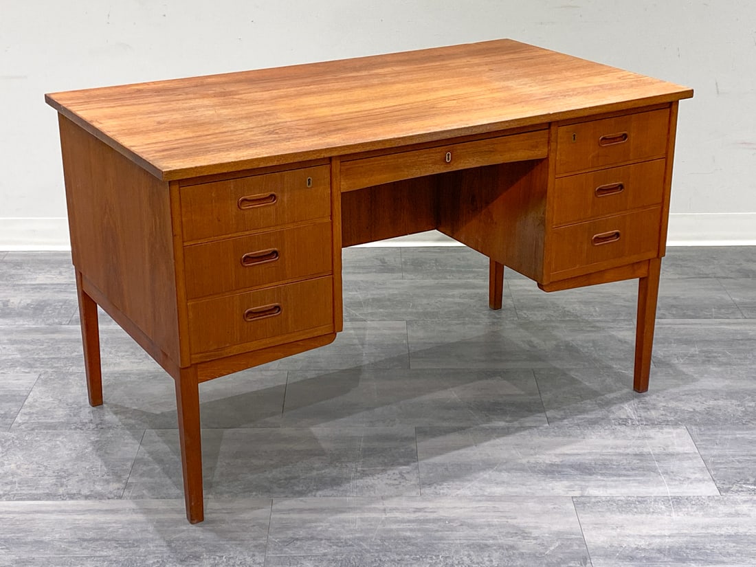 DANISH TEAK WRITING DESK C. 1960S: Key included. Six-drawer writing desk. Denmark, circa 1960s. Dimensions: H 29'' x W 48.25'' x D 27.25'' Condition: Wear consistent with age and use. Minor scuffs to edging. 1.00 teak