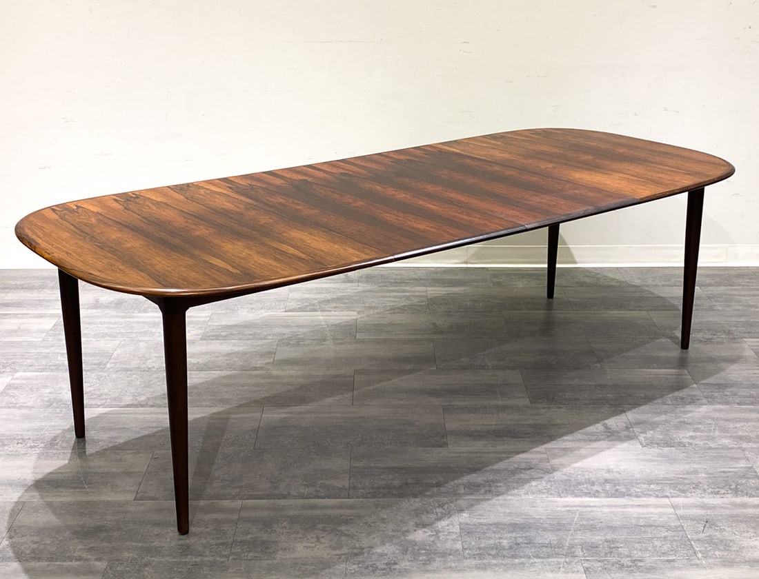 DANISH ROSEWOOD EXTENDING DINING TABLE C. 1960S: Two leaves included, stored within the table. Denmark, circa 1960s. Dimensions: H 29'' x W 58.5'' x D 42.5'' (Leaf) W 19.75" Condition: Wear consistent with age and use. Minor scuffs. Fading to top.