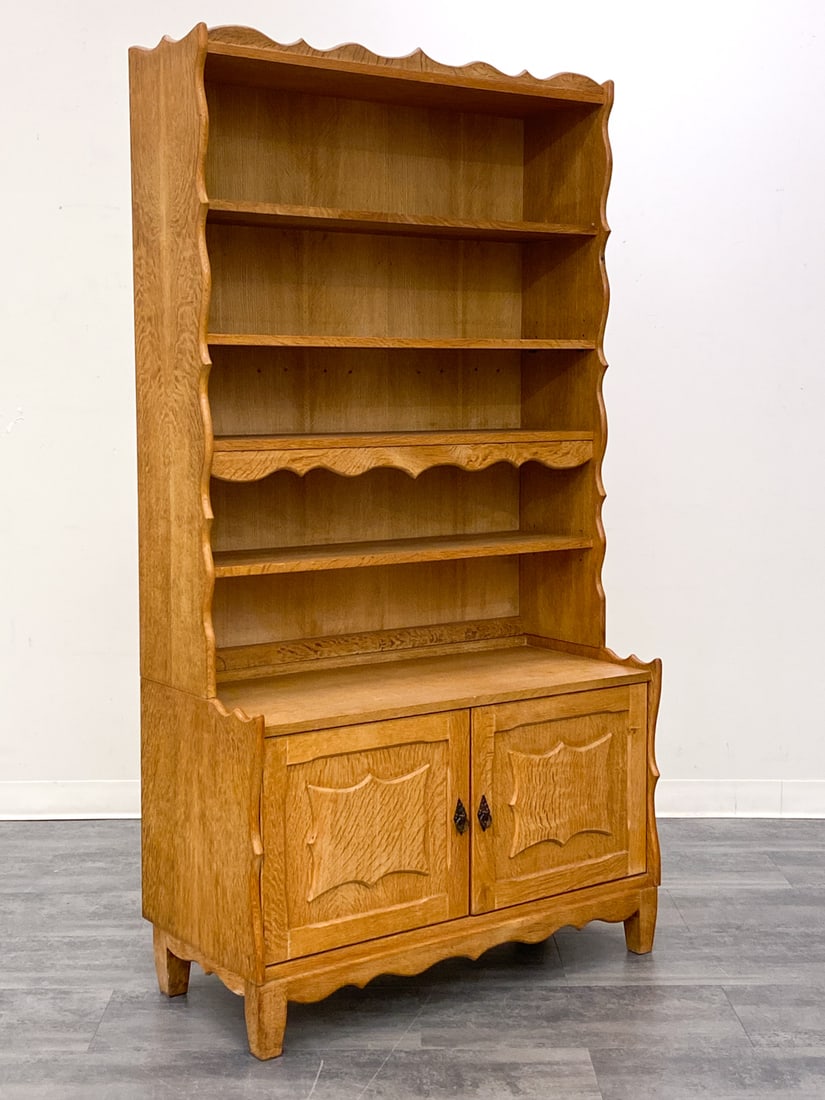 HENNING KJAERNULF DANISH OAK BOOKCASE C. 1970S: Adjustable shelves and bottom two-door cabinet. With JK Mobler tag on back, Denmark, circa 1970s. Dimensions: H 74'' x W 39'' x D 17.5'' Condition: Wear consistent with age and use. Scuffs, discolorat