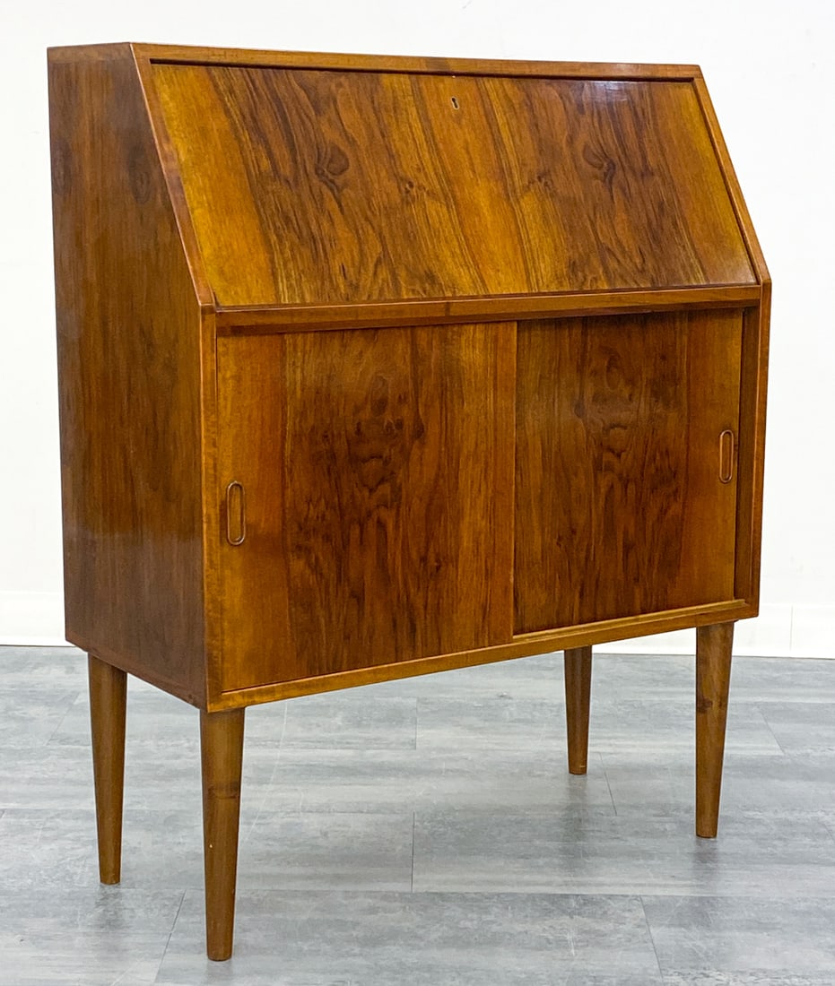 SCANDINAVIAN ROSEWOOD SECRETARY DESK C. 1960S: Key included. With drop front writing surface. and two sliding doors. Denmark, circa 1960s. Dimensions: H 43.5'' x W 35.5'' x D 16'' Condition: Wear consistent with age and use. One leg slightly warpi