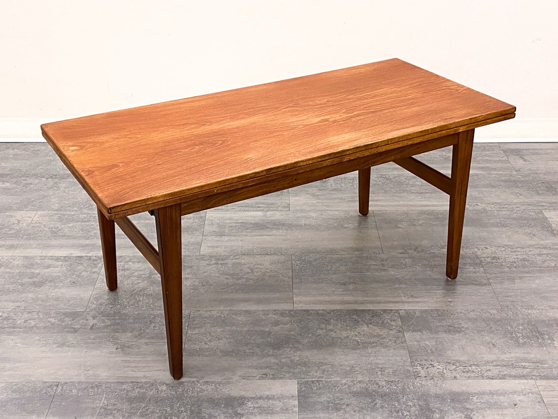 DANISH TEAK EXTENDING COFFEE TABLE C. 1960S: Two leaves included, stored within the table. Denmark, circa 1960s. Dimensions: H 22'' x W 47'' x D 21.5'' Condition: Wear consistent with age and use. Minor scuffs, discoloration.