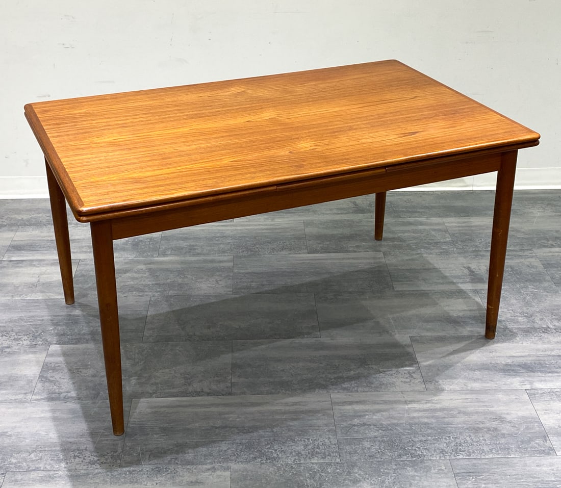 DANISH TEAK EXPANDING DINING TABLE C. 1960S: Two leaves included within the table. Denmark, circa 1960s. Dimensions: H 29.5" x W 55" x D 35" (Leaf) W 20.75" Condition: Surface marks and wear consistent with age and use. Scuffs to legs and minor