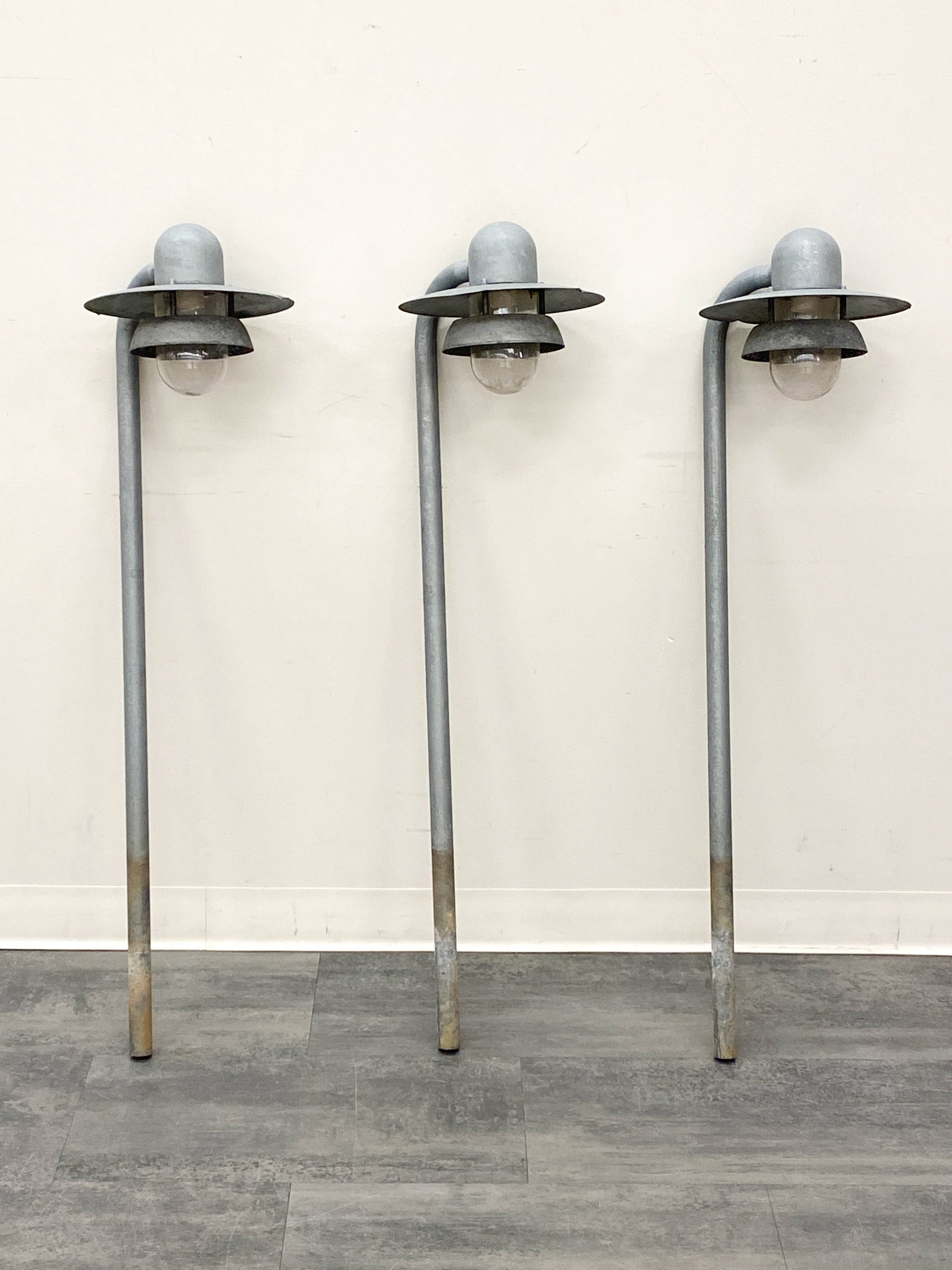 NORDLUX GALVANIZED STEEL OUTDOOR POLE LIGHTS: (3) Outdoor lights made from galvanized steel with glass diffusers. Tag remnants to sockets. Dimensions: H 45" x W 13" x D 11" Condition: Wear consistent with age and use. Wiring untested. Oxidizing,