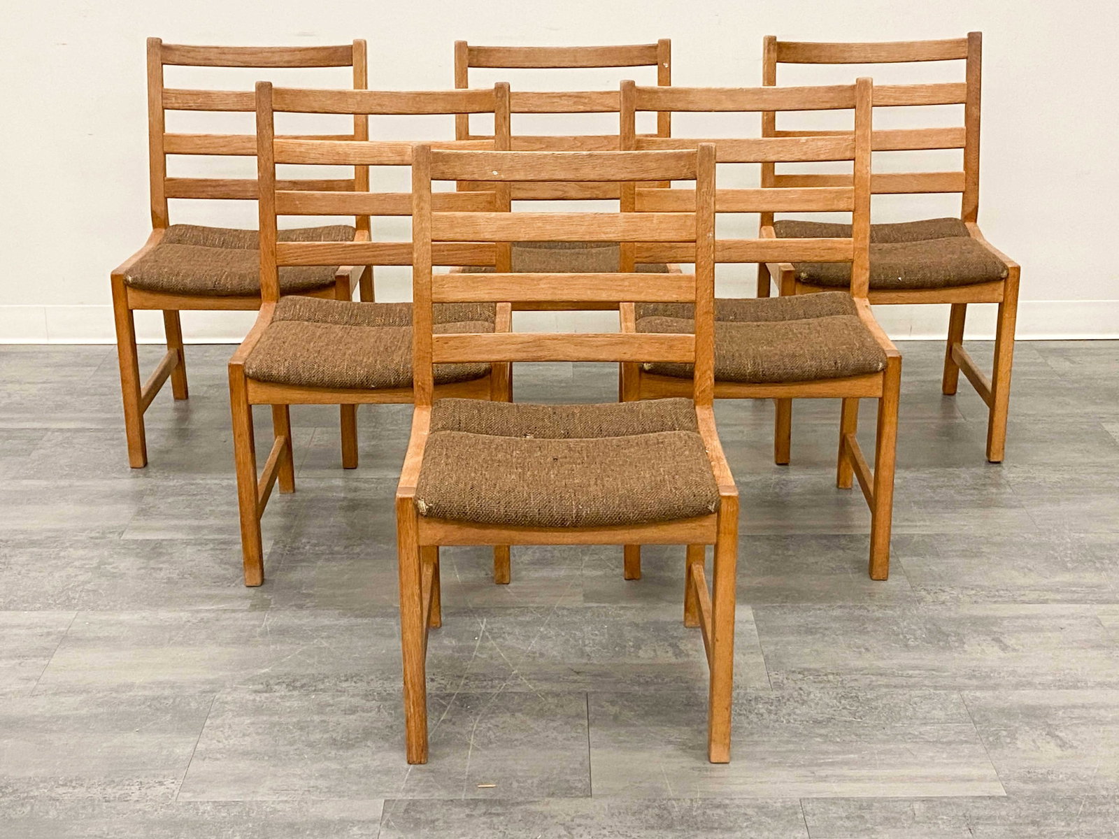 (6) K. P. MOBLER DANISH OAK DINING CHAIRS C. 1960S: Ladder backrest and brown upholstery. Marked underneath to frame. Denmark, circa 1960s. Dimensions: H 34" x W 20" x D 19" x SH 17.5" Condition: Wear consistent with age and use. Three chairs have ligh