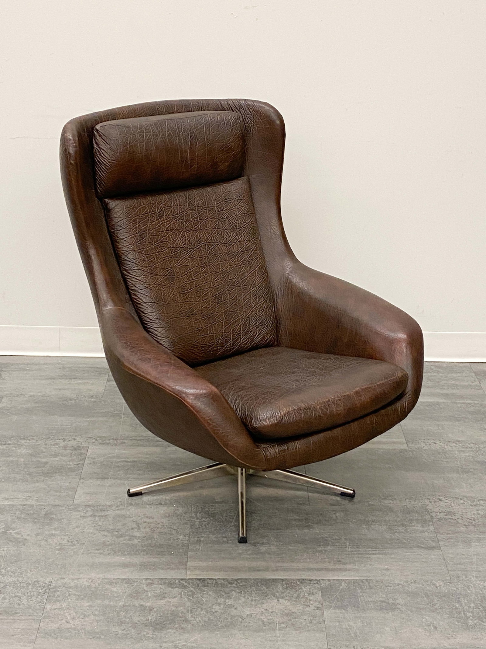 H. W. KLEIN FOR BRAMIN LEATHER LOUNGE CHAIR 1970S: Chrome swivel base and dark brown leather upholstery. Apparently unmarked. Denmark, circa 1970s. Dimensions: H 37" x W 30" x D 31" x SH 16" Condition: Wrinkled leather, Wear consistent with age and us