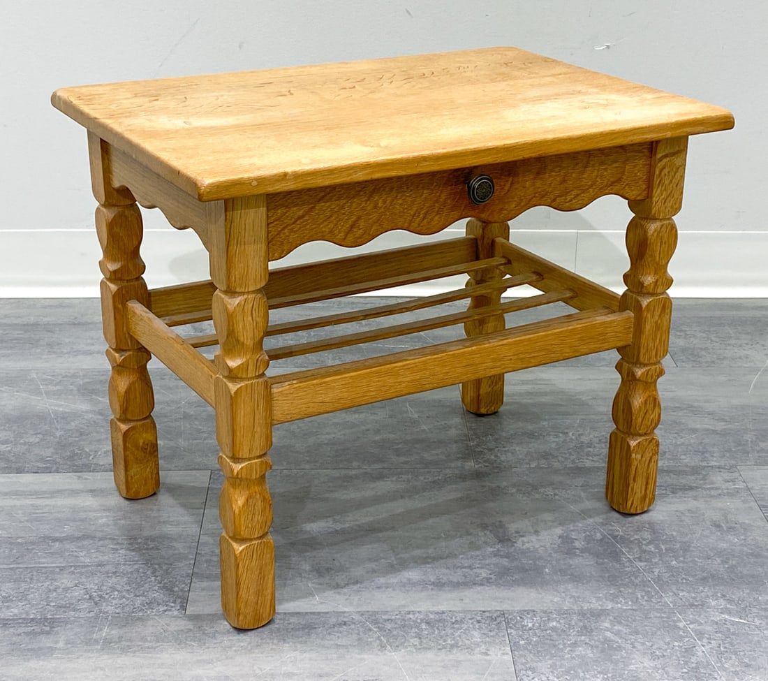 STYLE OF KJAERNULF DANISH OAK SIDE TABLE C. 1970S: Carved oak frame, one drawer with brass pull. Denmark, circa 1970s. Dimensions: H 17.75 x W 22 x D 16 Conditions: Wear consistent with age and use. Surface scratches, scuffs, and noticeable finish