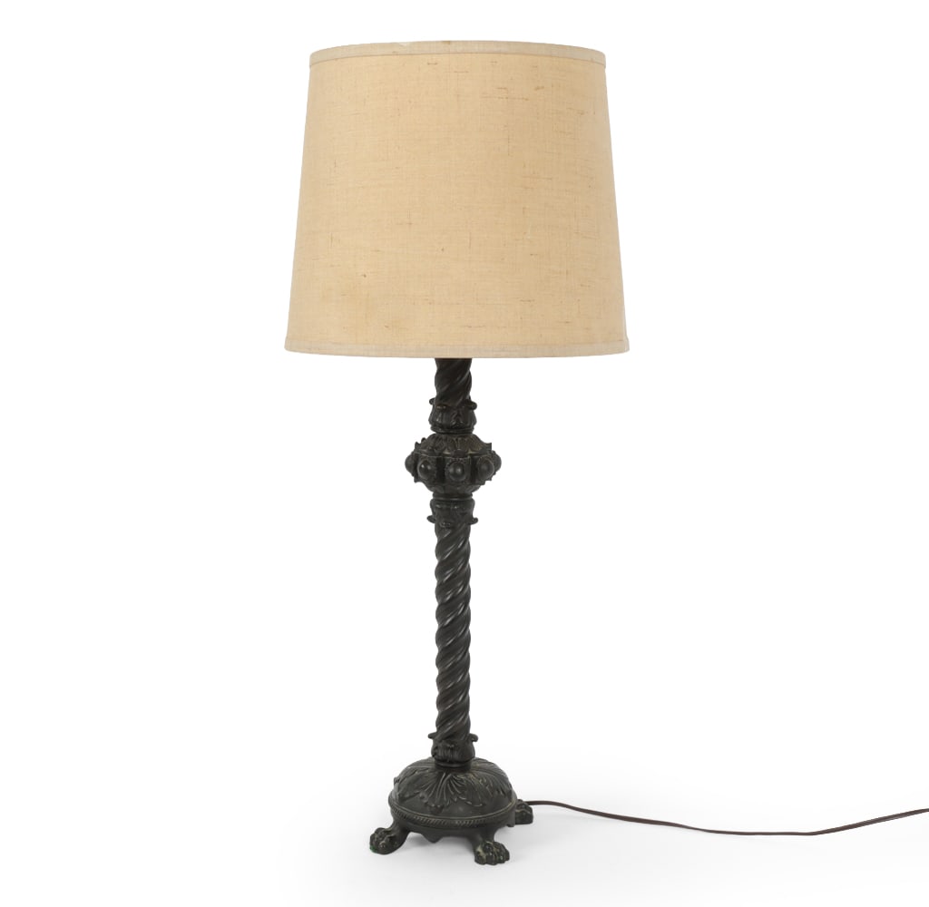 BRONZE REGENCY-STYLE TABLE LAMP: 19th Century cast bronze candleholder with lion's feet, mounted into a lamp. Dimensions: H 31" x W 13" Condition: Scuffs and patina of metal. Untested. Wear consistent with age and use.
