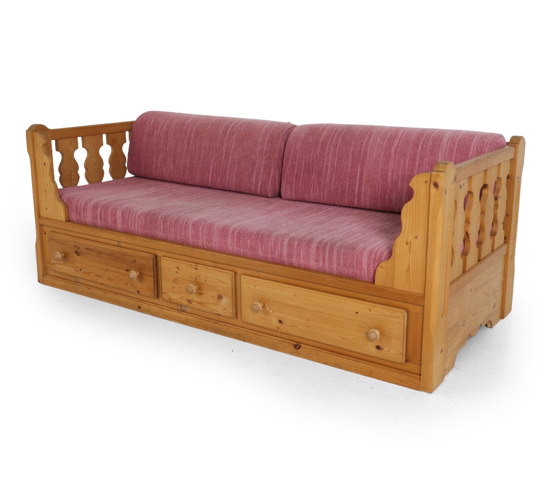 VOGLAUER AUSTRIAN PINE SOFA DAYBED: Marked inside drawer. Pine with upholstered cushions. "Bauerntisch" (farmhouse) style. Austria, circa 1980s. Dimensions: H 29.5" x W 78.25" x D 34.75" x SH 17.5" Condition: Scuffs, discoloration and w