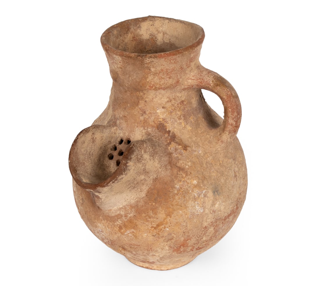 IRON AGE STONEWARE JUG C. 800-586 B.C.: Stoneware jug with a short trough-like strainer sprout. Iron Age II C. North and South. Dimensions: H 7.75" x W 6.25" x D 5.5" Condition: Burial remains, some flaking, wear consistent with age.