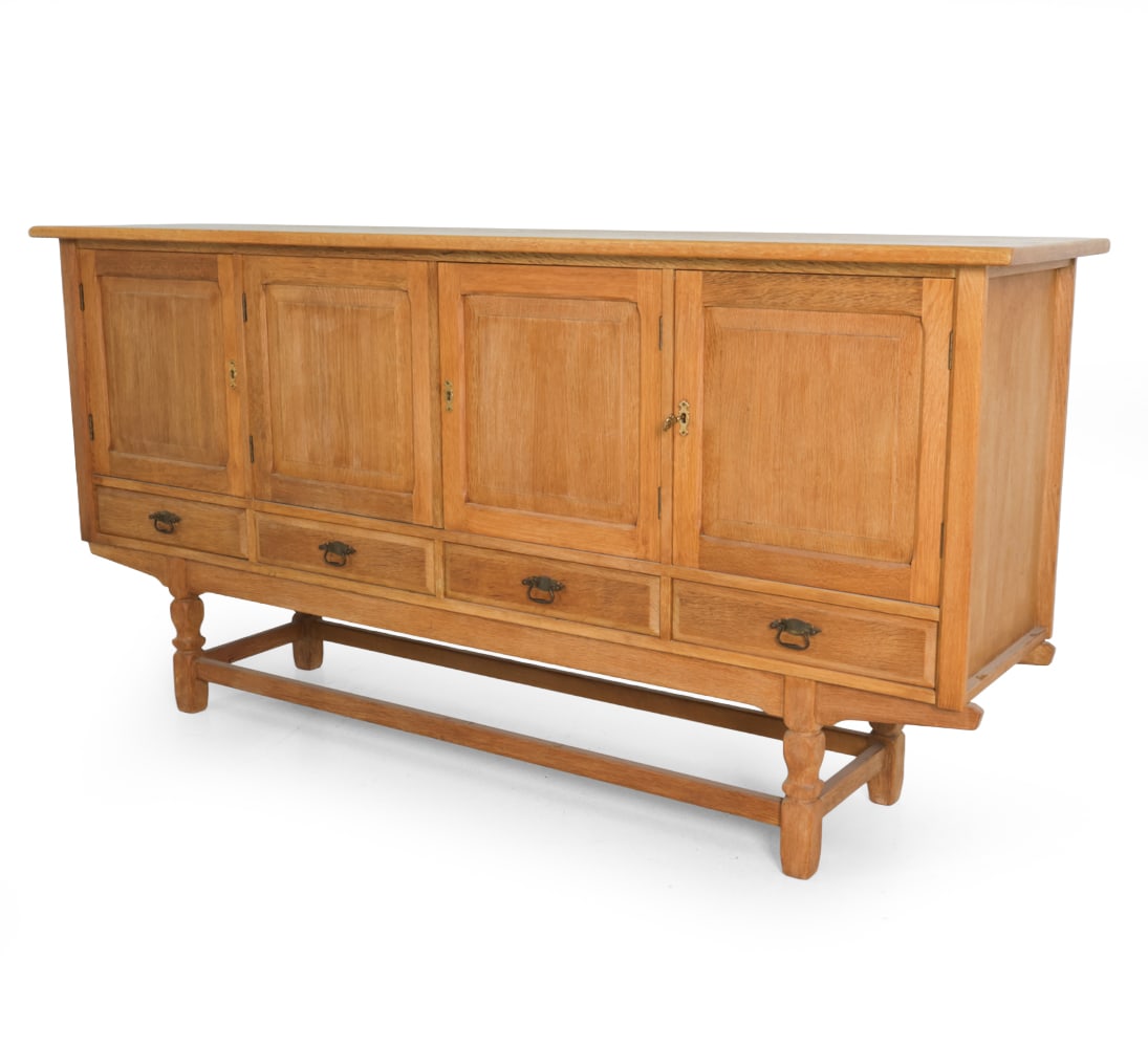 HENNING KJAERNULF FOR EG DANISH OAK SIDEBOARD: Key included. Oak frame and brass pulls. Apparently unmarked. Denmark, circa 1960s. Dimensions: H 40.5 " x W 82.5 " x D 19.5 " Condition: Wear consistent with age and use. Dings and scuffs. Surface ma