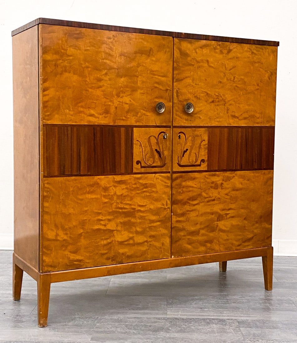 ATTR. MJOLBY INTARSIA SWEDISH ART DECO CABINET: Includes key. Inlaid botanical motifs to doors. Birch, mahogany, walnut burl frame. Sweden, circa 1930s. Dimensions: H 50" x W 49" x D 17.5" Condition: Wear consistent with age and use. Nicks, dings t