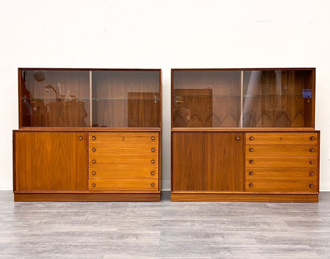PAIR AHLBERGS SWEDISH TEAK CABINETS 1960S: Glass sliding doors on top. Drawers and cabinets on the bottom. Key included. Marked to back of one unit. Sweden, circa 1960s. Dimensions: H 48.5" x W 53" x D 17.5" Condition: Wear consistent with age
