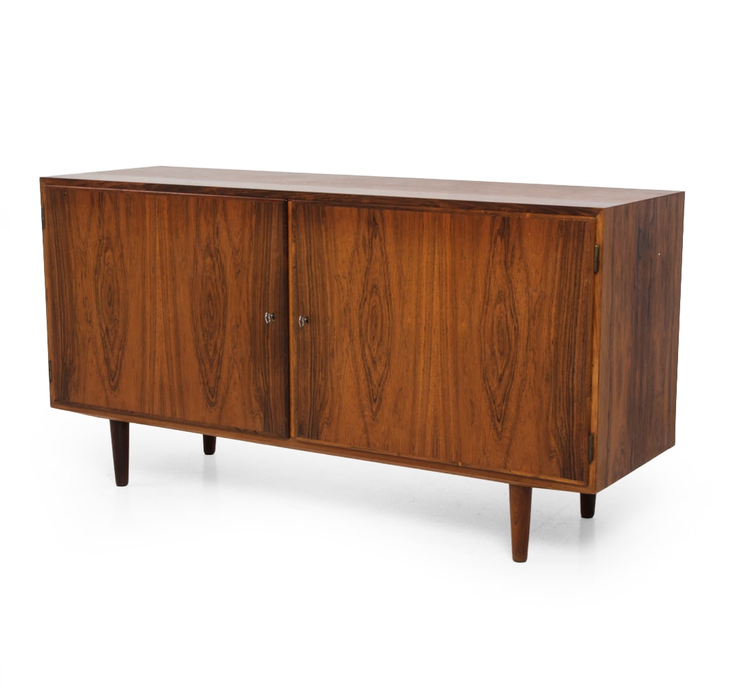 POUL HUNDEVAD DANISH ROSEWOOD CABINET C. 1960S: Key included. Rosewood frame. Marked to backside. Denmark, circa 1960s. Dimensions: H 28" x W 54.5" x D 17" Condition: Wear consistent with age and use. Some fading, scuffs, very light scratches, mino