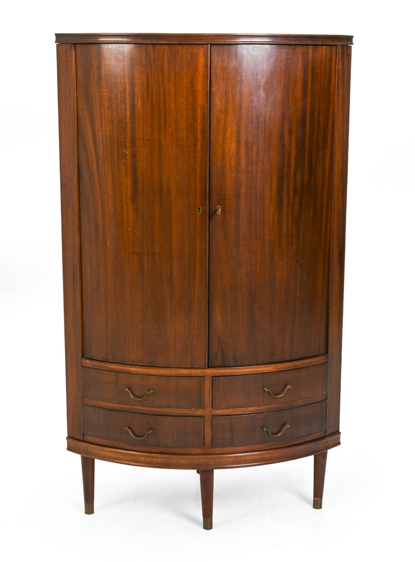 AGNER CHRISTOFFERSEN STYLE CORNER CABINET: Key included. Mahogany corner cabinet with four drawers, and brass hardware. Denmark, circa 1950s. Dimensions: H 57" x W 33.5" x D 23.75" Condition: Scuffs, fading, dings and scratches. Legs could