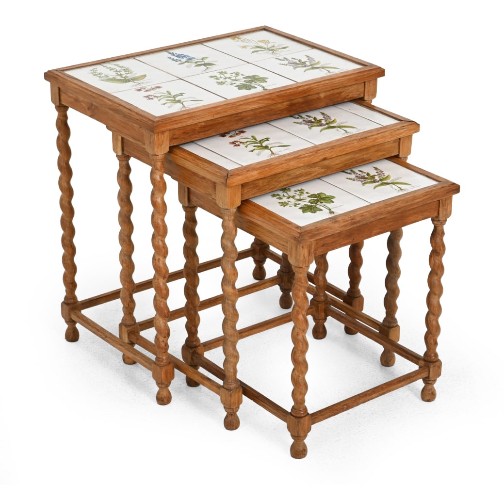 KJAERNULF STYLE DANISH OAK & TILE NESTING TABLES: (3) Oak nesting tables with turned legs and floral tiles. Denmark, circa 1970s. Dimensions: H 21.25" x W 19.5" x L 13.25" Condition: Fading, loose joinery. Tile top has crazing and glazing